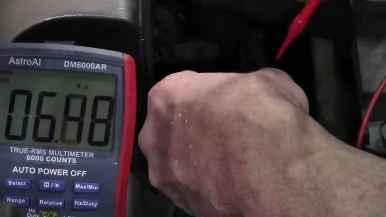 Multimeter displaying 'OL' (Out of Limit) indicating an open circuit in the O2S heater.